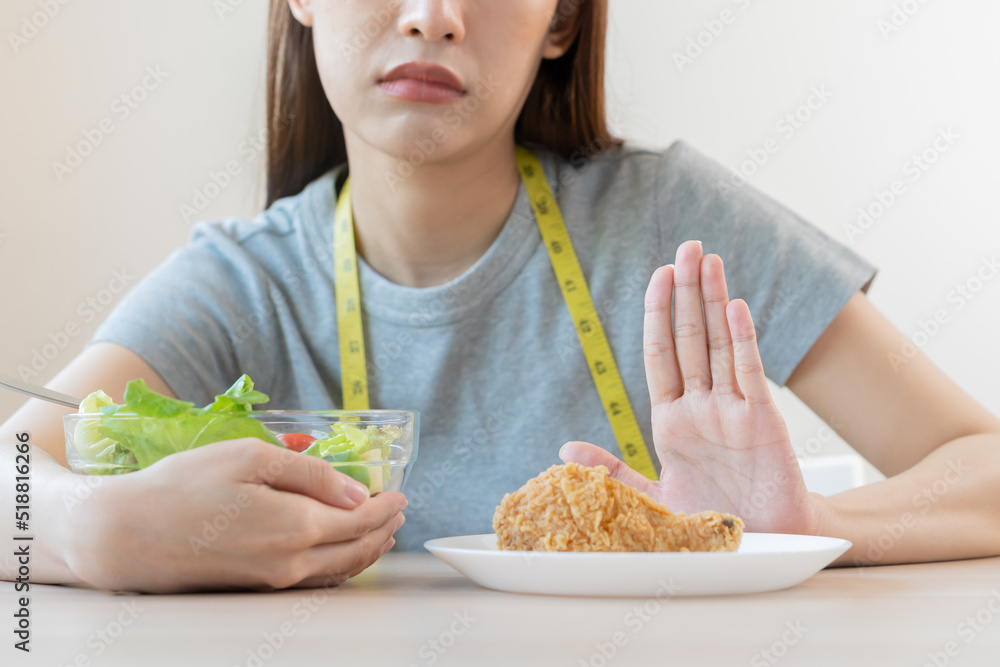 Diet, Dieting asian young woman or girl push out, deny fried chicken, junk food and choose fresh vegetables salad of bowl, eat food for good healthy, health when hungry. Female weight loss people Diet, Dieting asian young woman or girl push out, deny fried chicken, junk food and choose fresh vegetables salad of bowl, eat food for good healthy, health when hungry. Female weight loss people