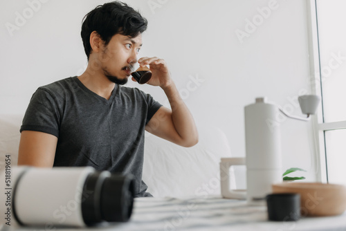 Asian man make and drink his own french press coffee.