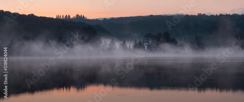 A panorama of the mist rising off of Spruce Knob Lake during a summer morning sunrise.