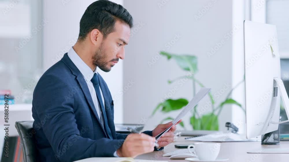 Financial advisor reading a checklist and taking notes in a diary while working in an office alone. One serious male Asian finance manager organizing papers and documents for a client at work Financial advisor reading a checklist and taking notes in a diary while working in an office alone. One serious male Asian finance manager organizing papers and documents for a client at work