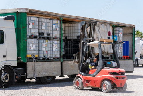 Photo Forklift unloading a truck with empty drums used to transport dangerous goods