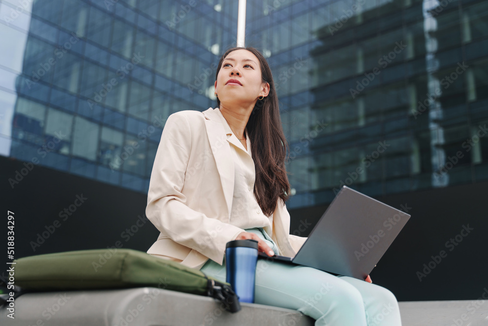 Young Asian Professional Business Woman working with laptop outside the ...