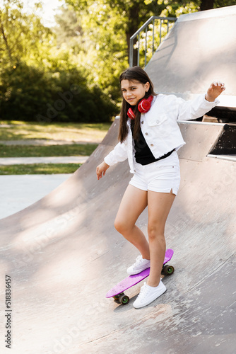 Teenager girl ready for ride on penny board on skateboard park playground. Sports equipment for kids. Extreme lifestyle.