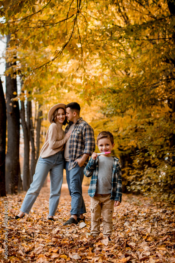 Young family, husband, wife and young son holding a positive pregnancy test, waiting for replenishment in the family. Family autumn photo shoot