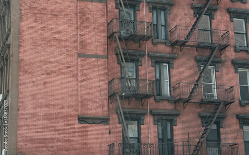 Brown bricks of brownstone apartments with staircases in Manhattan New York