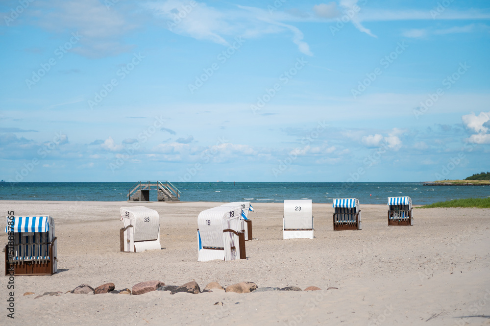 Sunny beach with white sand and wicker beach chair in north Germany