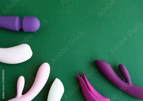 Collection of different types of sex toys on a green background. 