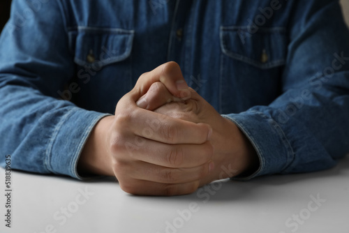 Schilderij op canvas Man clenching hands at table while restraining anger, closeup
