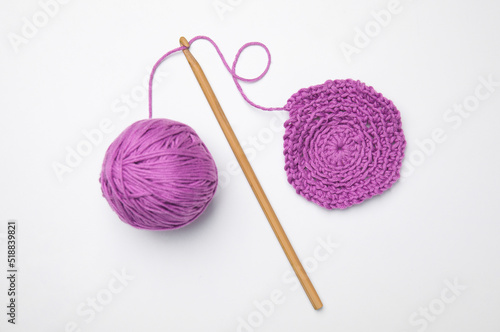 Soft violet woolen yarn, knitting and crochet hook on white background, top view