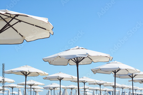Beautiful white beach umbrellas against blue sky