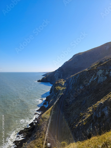 Aerial view of mountain road near blue sea, sandy beach at sunset in summer. Oludeniz, Turkey. Top view of road, trees, clear water, mountain. Beautiful landscape with highway, rocks and sea coast