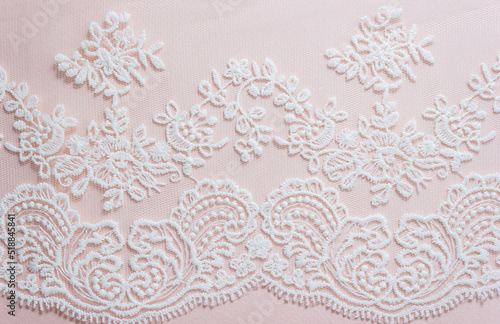 White lace on pastel background. Element of the bride's dress or veil. The concept of wedding invitation