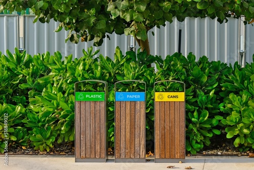 Modern wooden garbage bins for separate waste collection in public city park in Abu Dhabi,UAE. Urban ecology. Environmental care.