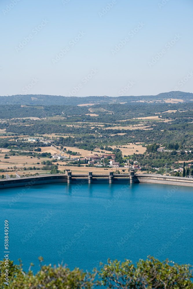 Fototapeta premium Large blue reservoir and distant hydro-electric dam