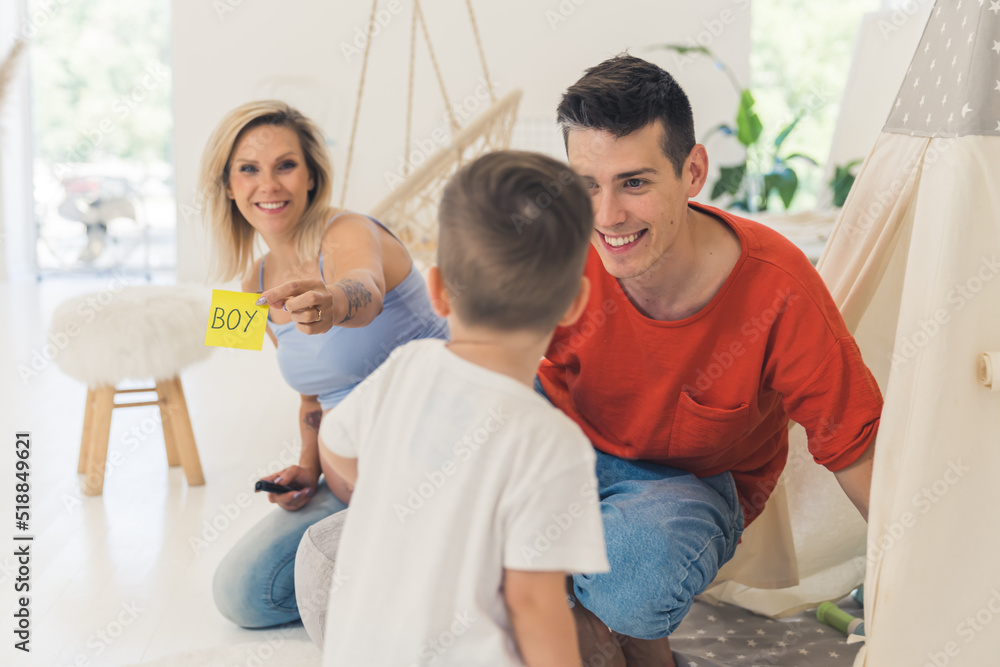 Fototapeta premium Young parents surprise their toddler boy with a gender reveal of their second child. Healthy relationships concept. Family growing. High quality photo