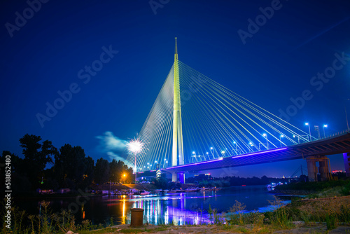 Ada bridge on river Sava in Belgrade Serbia nightscape with fireworks in background and marina on another bank