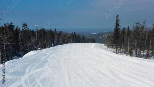 Picturesque view of sport and recreation resort for winter vacation, healthy lifestyle concept. Footage. Aerial for young teenagers snowboarding and skiing down the hill on winter forest background. © Media Whale Stock