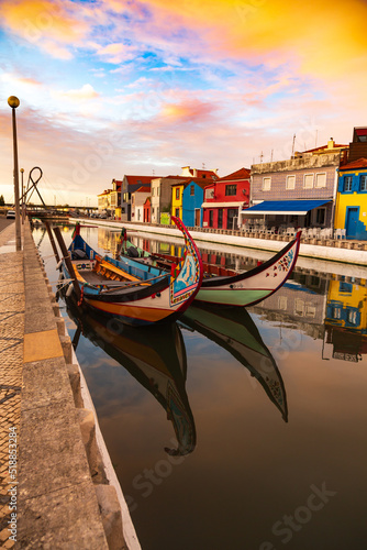 Aveiro, Portugal, Traditional colorful Moliceiro boats docked in the water canal among historical buildings. © Michal Ludwiczak