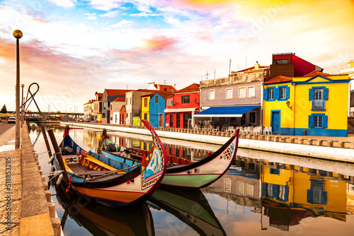 Aveiro, Portugal, Traditional colorful Moliceiro boats docked in the water canal among historical buildings.