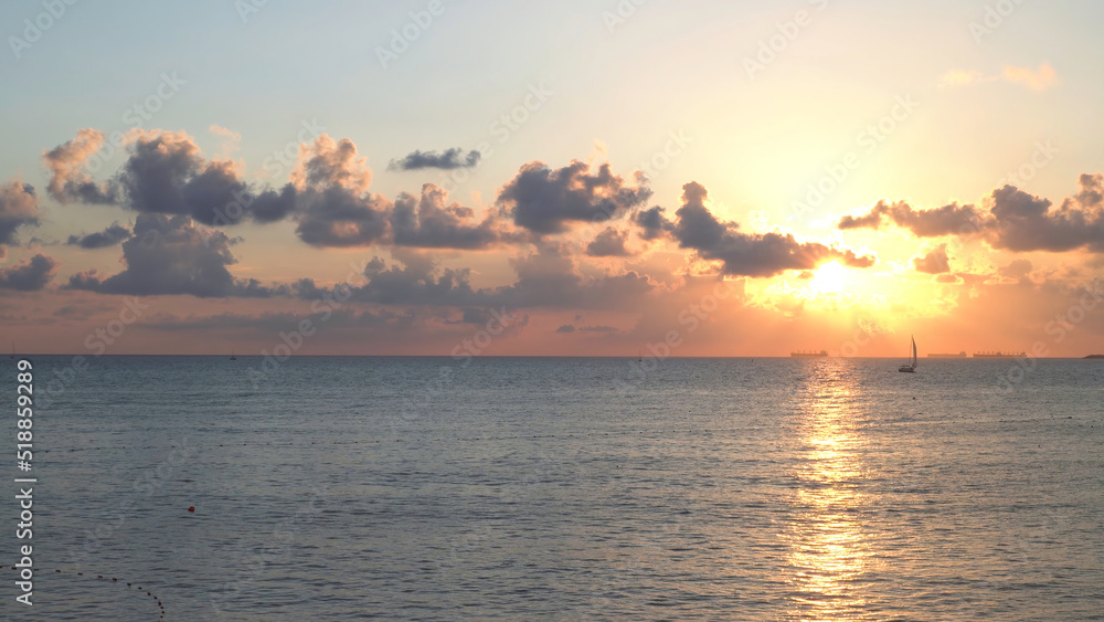 Fototapeta premium Breathtaking marine landscape with yachts in the sea at sunset. Media. Romantic view of bright sunset over the calm black sea with sailing ships and yachts.