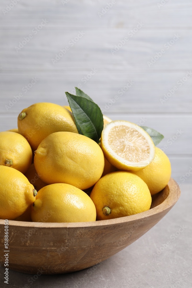 Many fresh ripe lemons on light grey table