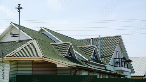 Green roof coating. Stock footage. Beautiful green roof is made of profiled flooring. New roof covering of country house. Multi-pitched roof with windows on sides