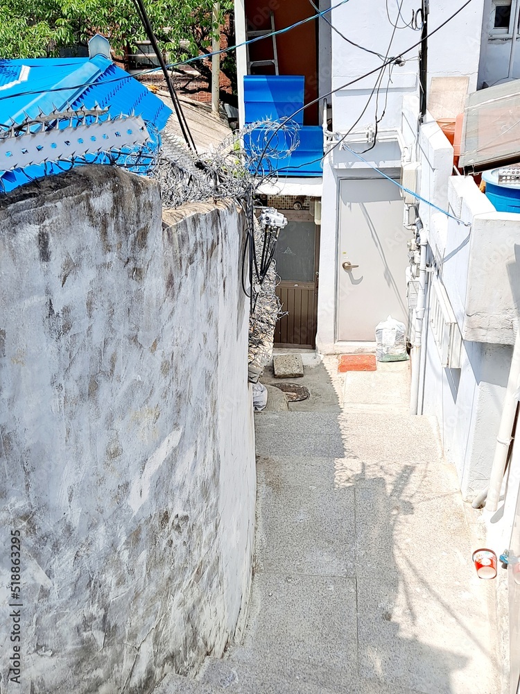 Fototapeta premium Vintage house with blue roof and white facade in an old town alley in Seoul, South Korea