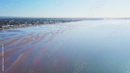 Populated coastal area at low tide with exposed sand flats, aerial