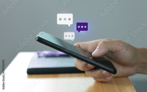 Women hand using smartphone typing, chatting conversation in chat box icons pop up. Social media maketing concept.