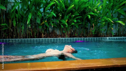 Young asia woman with red bikini playing in swimming pool, relaxation woman in swimming pool, Woman in bikini floating in swimming pool