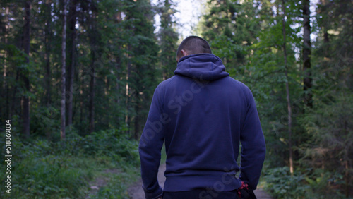 Photos Rear view of male hiker standing in forest