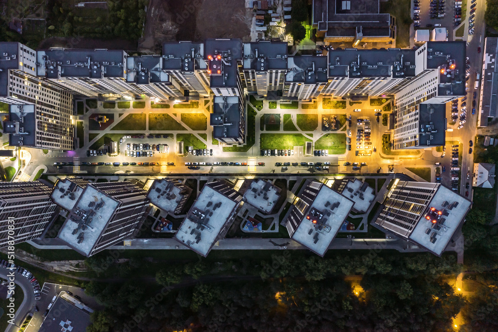 aerial top view of a courtyard of high-rise residential buildings with parking lot at night