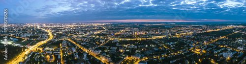 panoramic view of illuminated city streets and buildings after sunset. aerial view from flying drone.