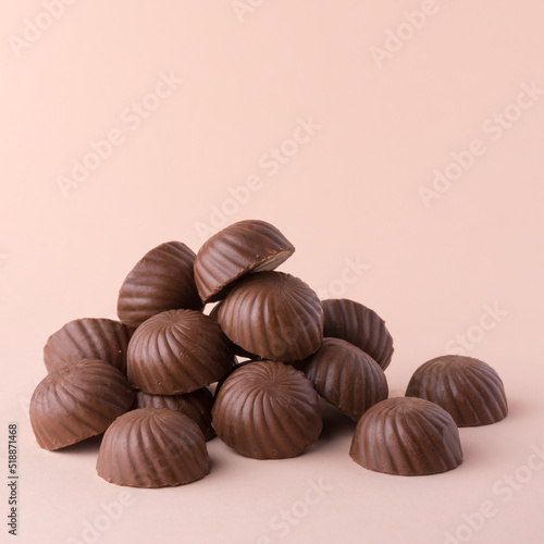 heap of chocolate candy or sweets, on lighter background, closeup