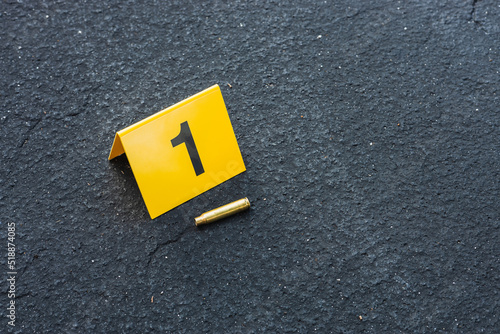 Obraz na plátne One yellow crime scene evidence marker on the street after a gun shooting brass
