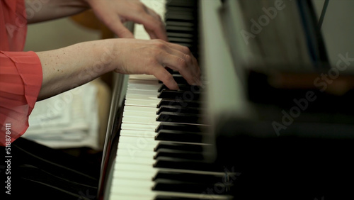 Girl's hands on the keyboard of the piano. The girl plays piano,close up piano. Hands on the white keys of the Piano Playing a Melody. Women's Hands on the keyboard, Playing the Notes Melody.