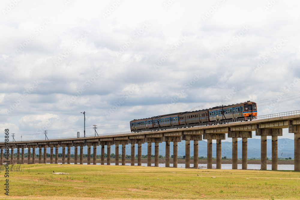 The train is running on floating railway track that passes through the grasslands at Pa Sak Jolasid Dam.Thailand.