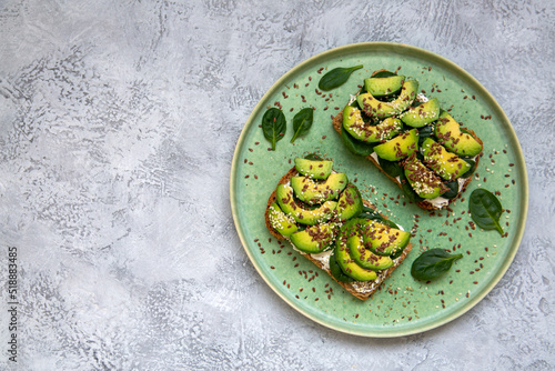 Toast with avocado, cottage cheese, spinach, sesame seeds, flax seeds. Healthy food rich in fiber, trace elements, omega acids, unsaturated lipids.