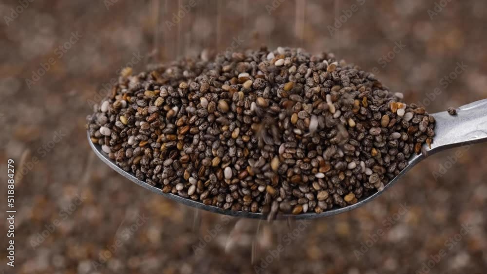 Close-up chia seeds falling from a spoon. Macro shot. Close-up chia seeds falling from a spoon. Macro shot.