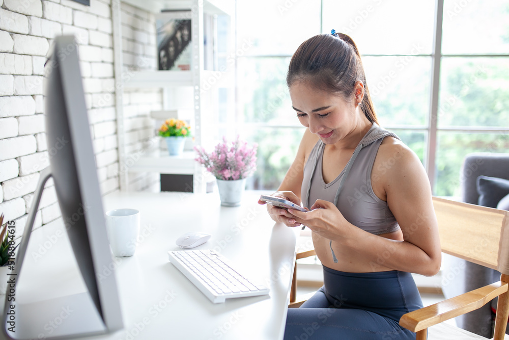 Obraz premium Young Asian woman using laptop computer checking social media application on website online at home, feel relax and enjoy communicate and discuss in living room.
