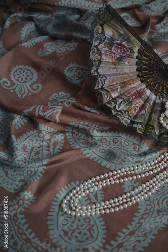 Azerbaijani national national silk scarf called Kelagayi still life with pearls and fan  studio shooting photo