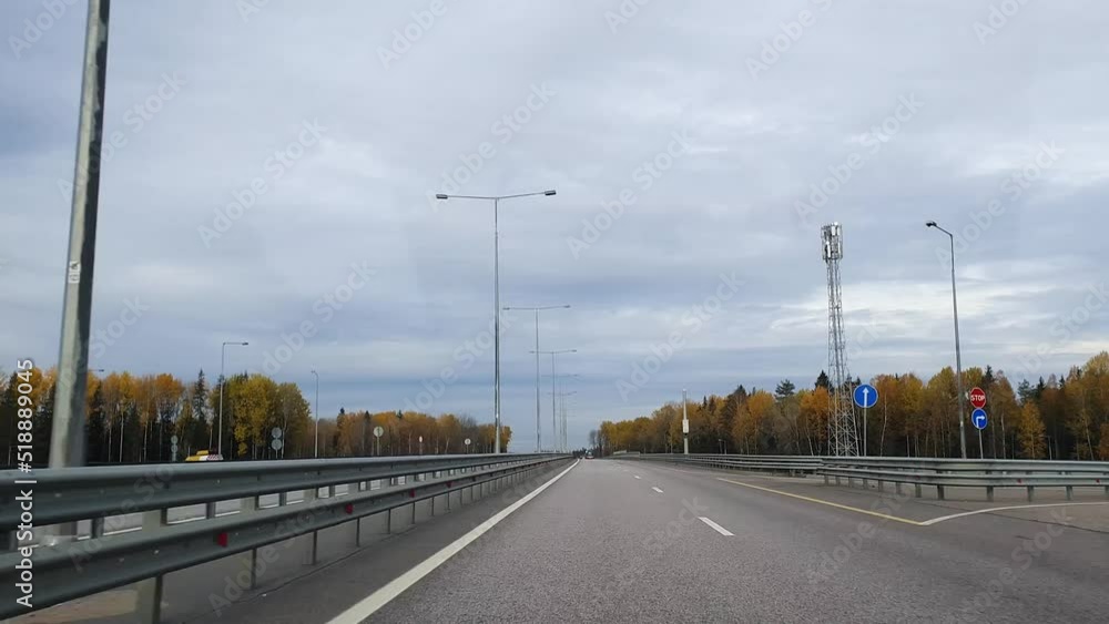 Driving a car on asphalt empty road highway with color trees in autumn Driving a car on asphalt empty road highway with color trees in autumn