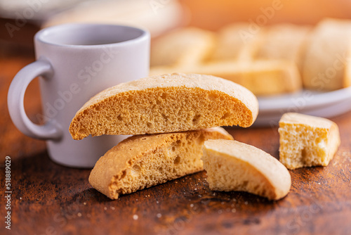 Sweet anicini cookies. Italian biscotti with anise flavor and coffee cup on wooden table.