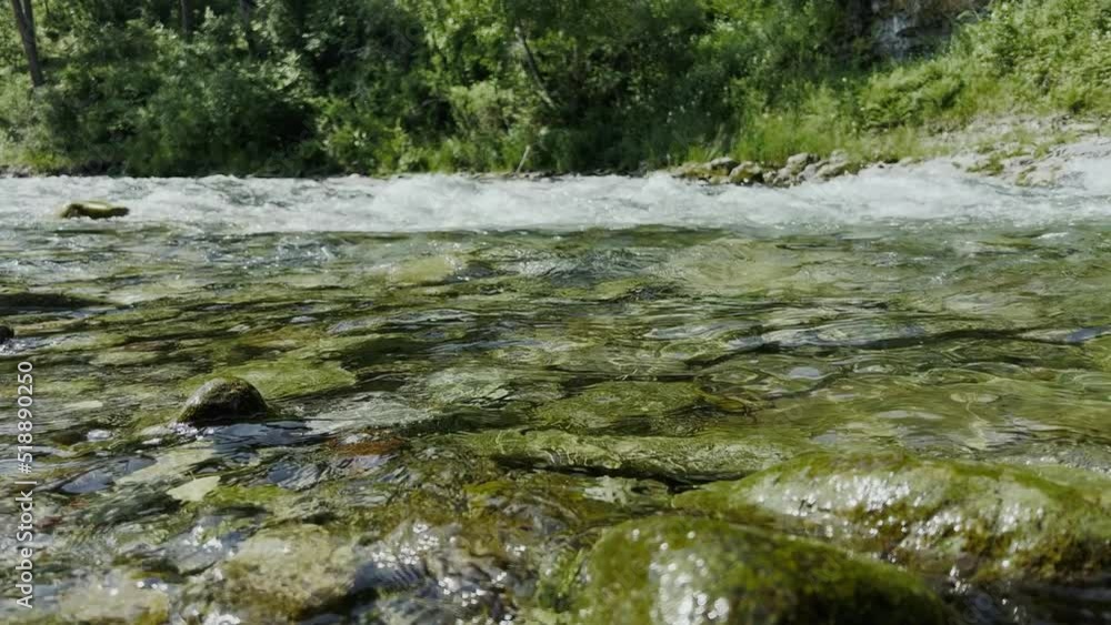The flow of a mountain river. Waves on the surface of the water. High quality 4k footage The flow of a mountain river. Waves on the surface of the water. High quality 4k footage