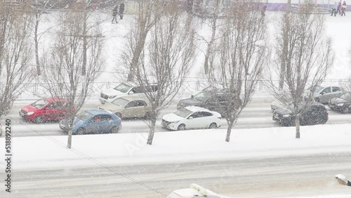 Snow falling down over the city. heavy snowfall and blizzard in the city. snowy road. cars driving in the snow