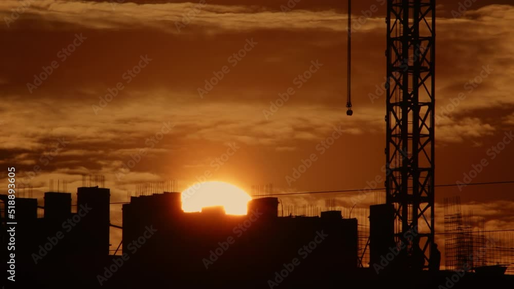 Timelapse, sun is setting behind building under construction. Timelapse, sun is setting behind building under construction.