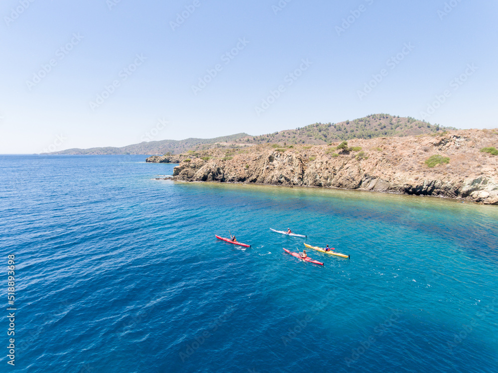 Aerial view of group of people canoeing in turquoise water of Mediterranean Sea