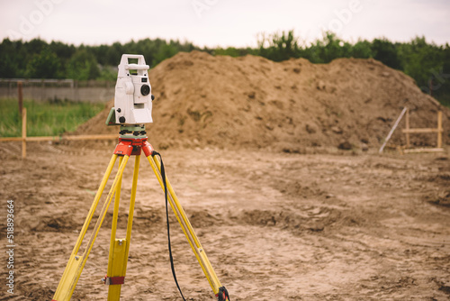 Surveyor equipment - GPS system or theodolite total positioning system outdoors at house construction site. Surveyor engineering with total station before house building