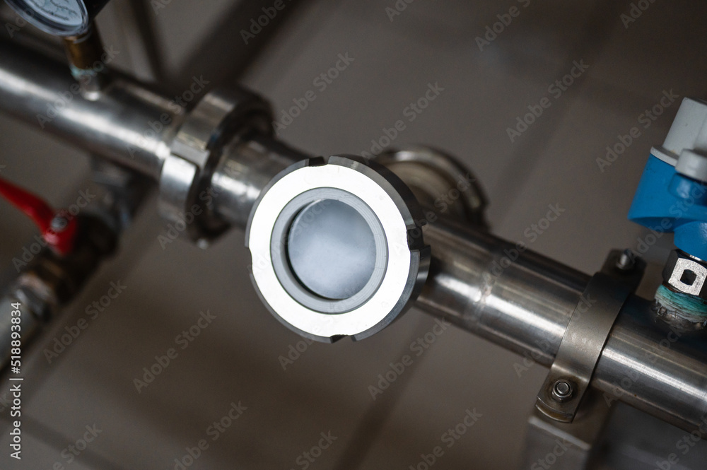 Liquid meter on grey metal pipeline with flanges at plant Liquid meter on grey metal pipeline with flanges at plant