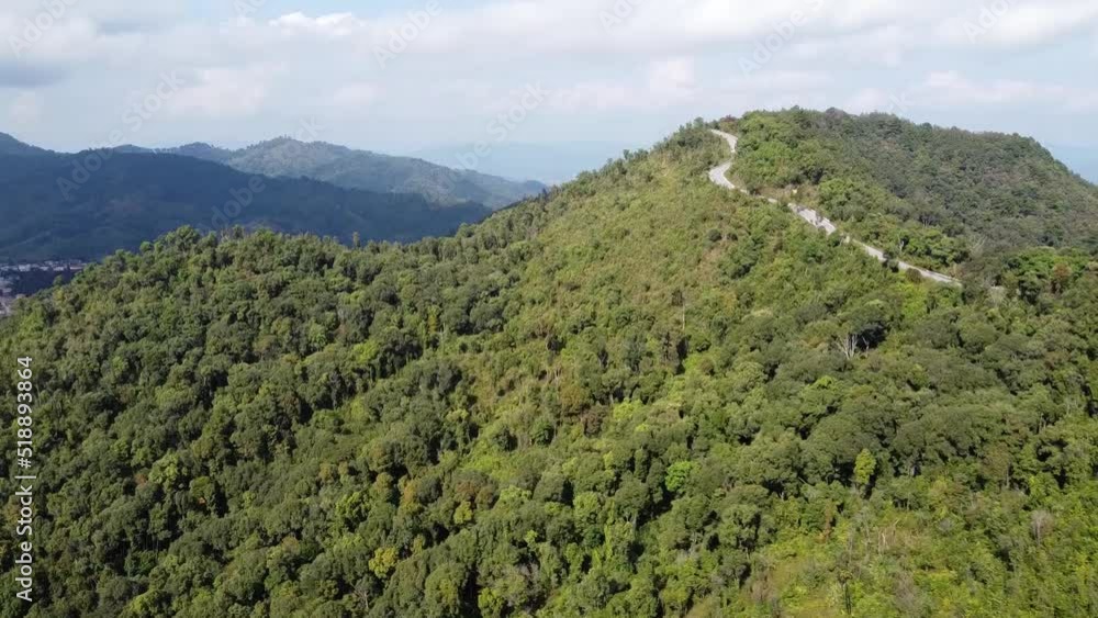 Aerial view of car runs on a long road up a mountain with a green forest, Thailand. Aerial view of car runs on a long road up a mountain with a green forest, Thailand.